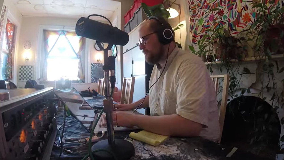 Dan Deacon hard at work in his studio with headphones and a laptop