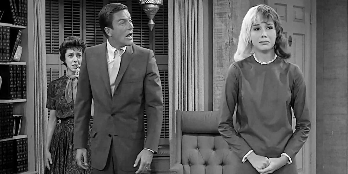 Mary Tyler Moore with half blonde half brunette hair with her hands clasped, Dick Van Dyke standing behind her staring at her in shock, Ann Guilbert standing behind Van Dyke with a worried look on her face