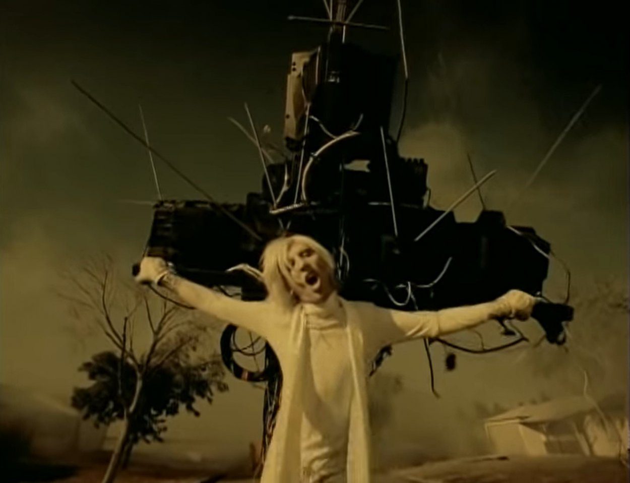 Marilyn Manson hanging from a crucifix made of TVs in the "I Don't Like the Drugs (But the Drugs Like Me)" music video