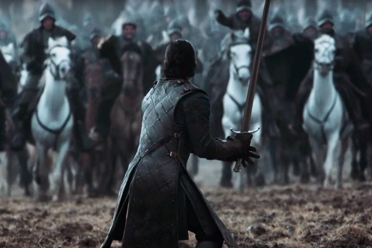 Jon Snow stands with his sword drawn waiting for the oncoming cavalry
