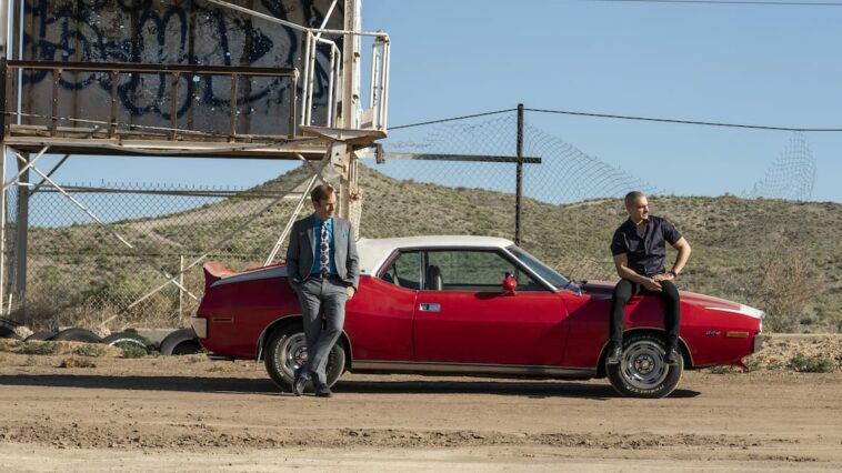 Jimmy and Nacho lean against Nacho's car in the desert waiting for Lalo to arrive