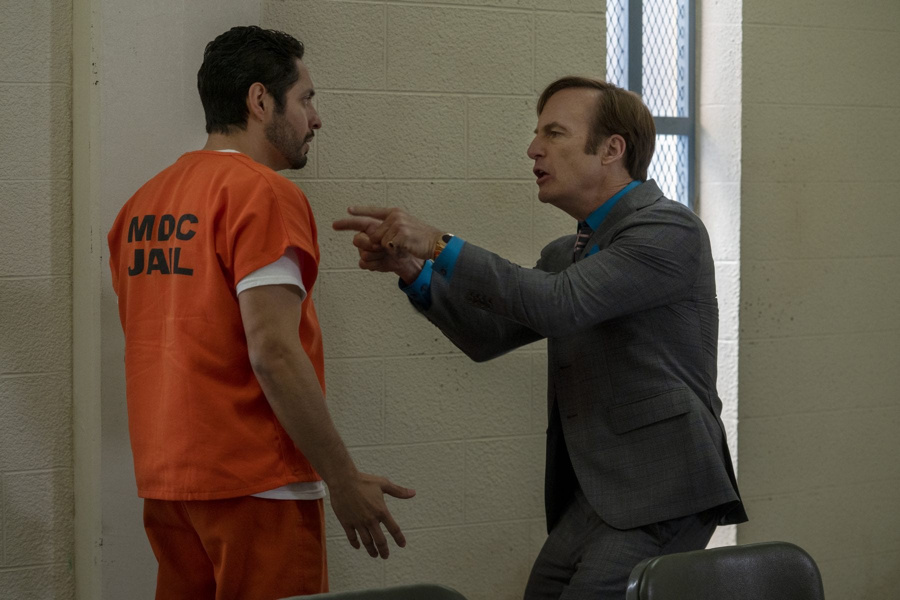 Jimmy points at Domingo wearing an orange prison jumpsuit in the interrogation room