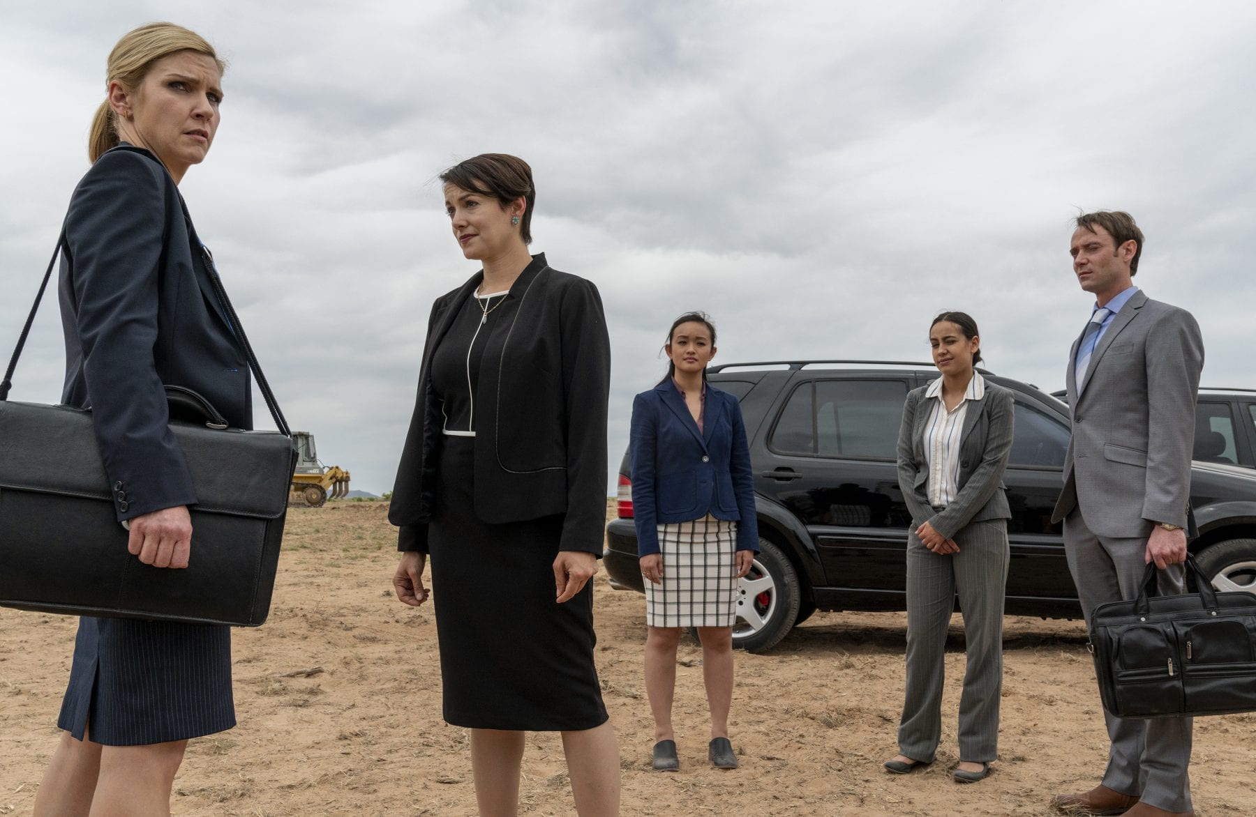 Kim, Paige, and three associates stand in front of a black SUV at the Tucumcari build site