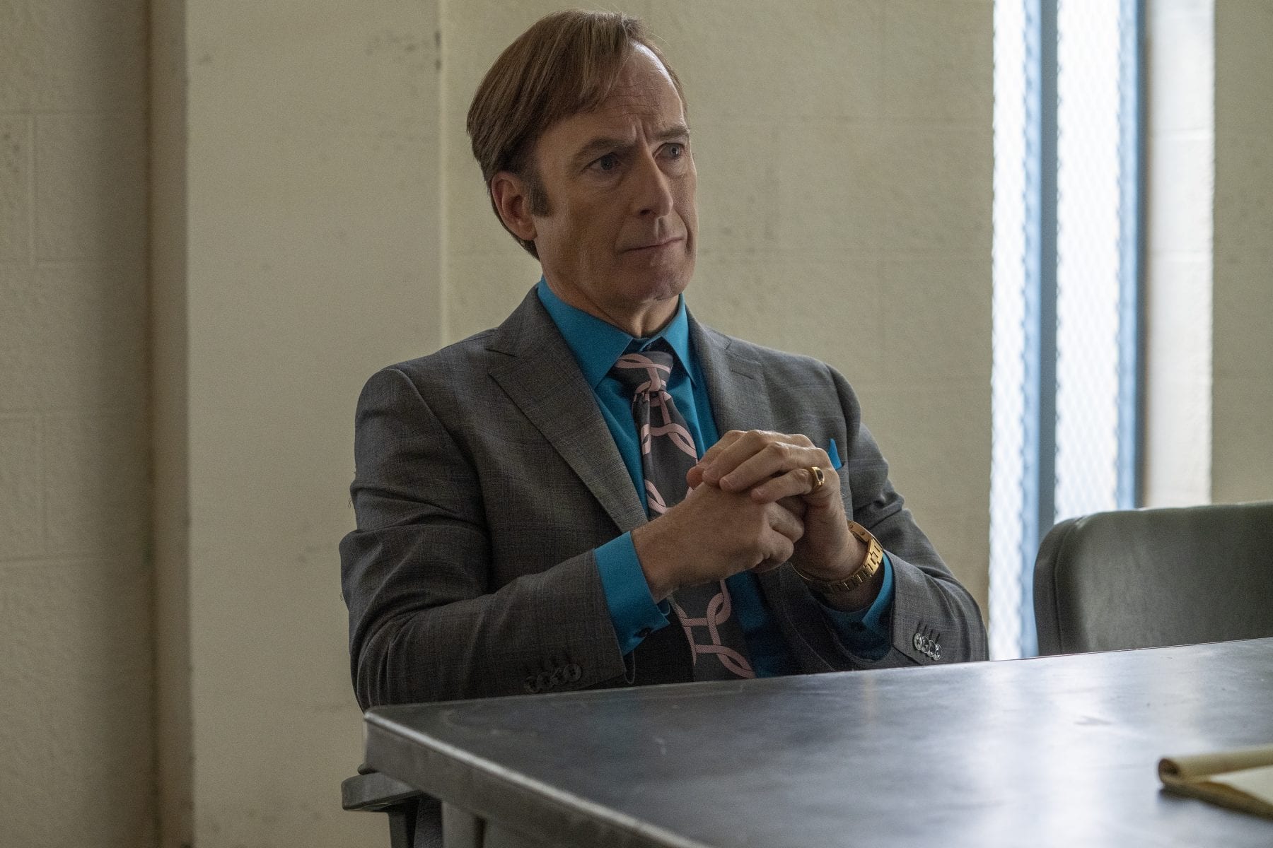 Jimmy sits at the table in the interrogation room practicing law as Saul Goodman 
