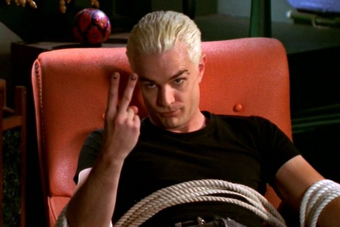 Spike , tied up in a chair, giving an obscene gesture to the camera