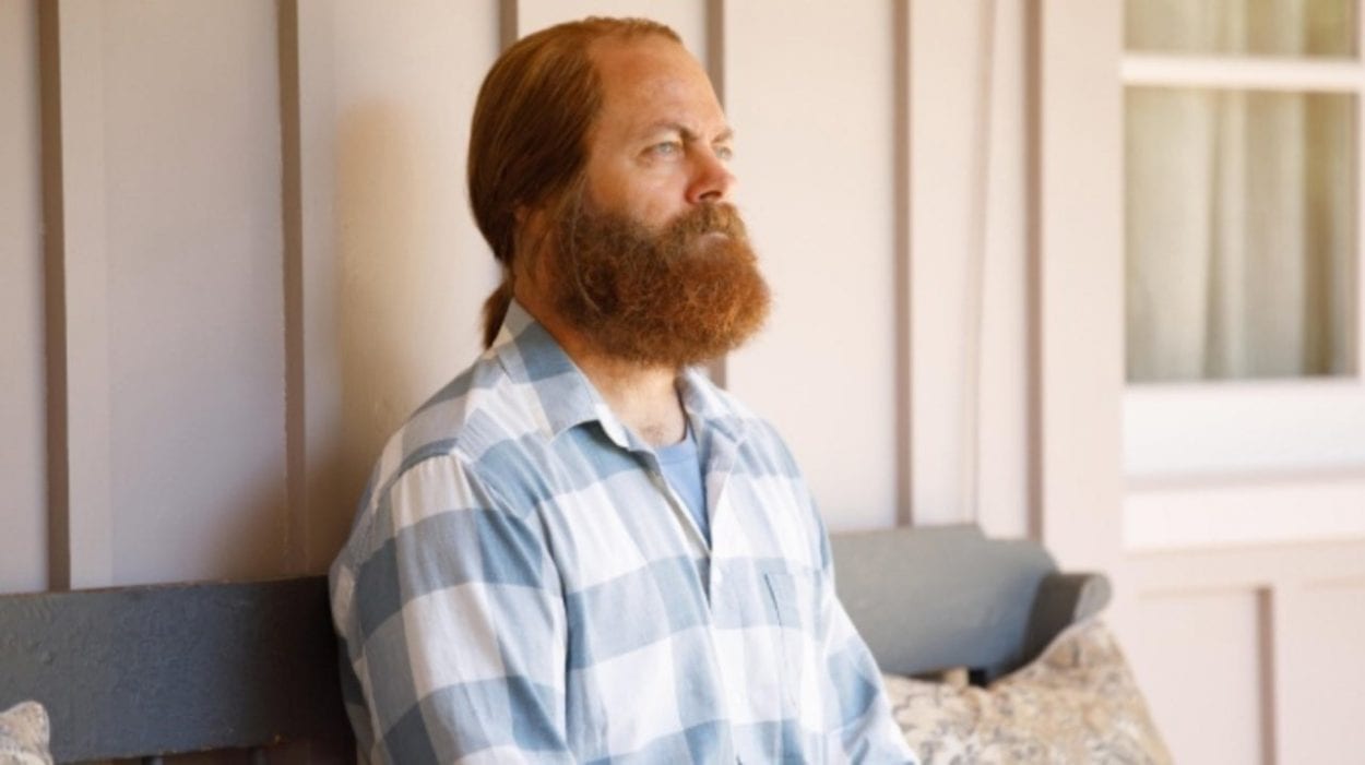 Forest, with his hair tied back and full beard, wearing a blue striped shirt