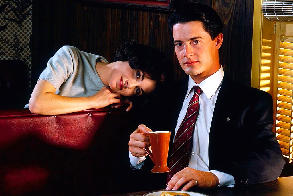 Agent Cooper and Audrey horney sit in a booth of the Double R diner