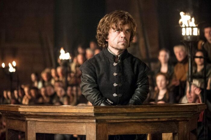 Tyrion Lannister stands in a courtroom wearing handcuffs