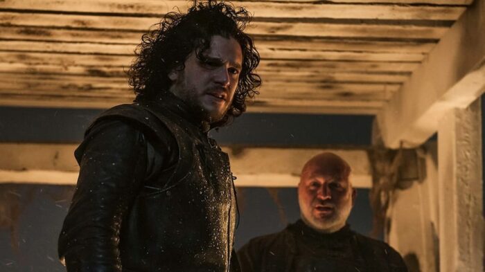 Jon Snow and Janos Slynt stand at the top of the Wall