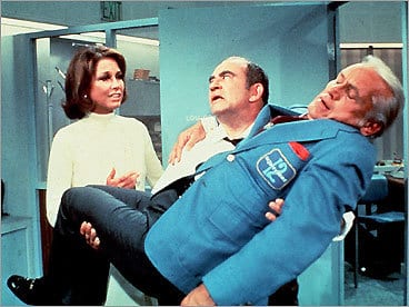 Lou Grant carries Ted Baxter after passing out