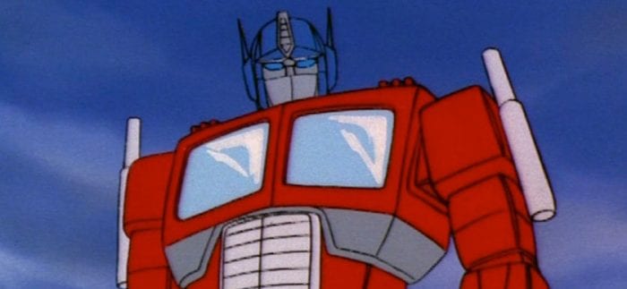 The big red truck with a blue robot head, Optimus Prime, stands heroically before the camera.