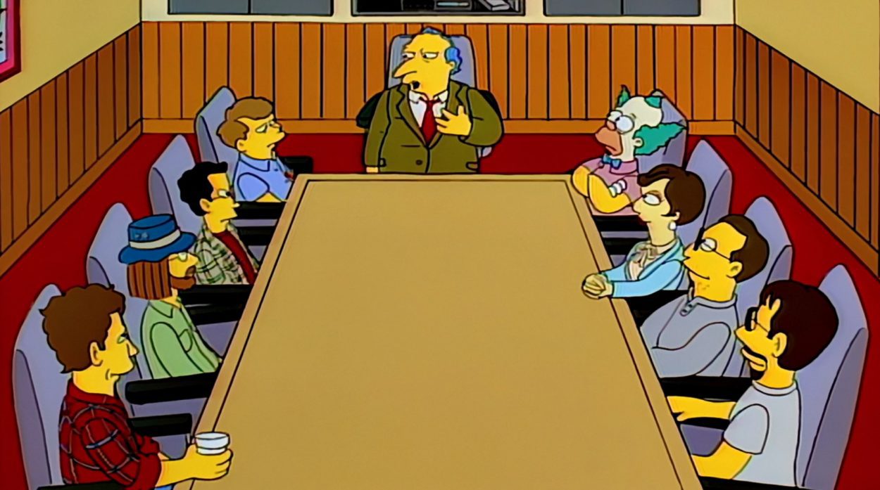 Simpsons writers sit around a table