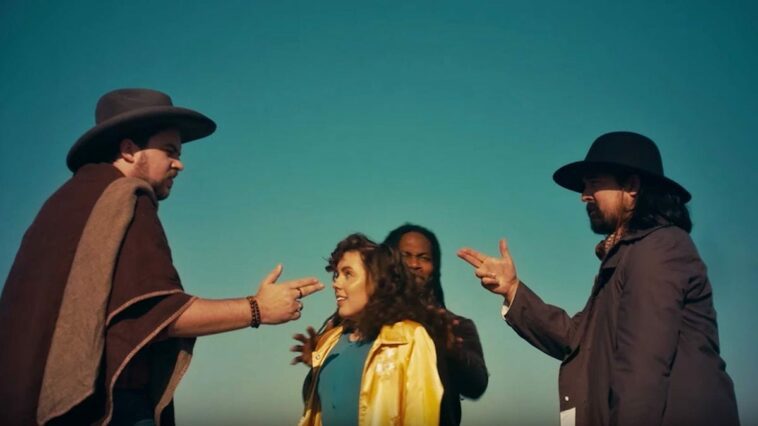 A scene from the music video for "Future Peg" shows Man Man singer Honus Honus and a man in a poncho pointing finger pistols at one another while a man and woman stand between them.