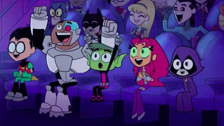 Robin, Cyborg, Beast Boy, Starfire and Raven cheer in a moovie theater filled with fellow superheroes.