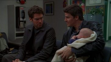 Concerned, Wesley looks at Angel holding baby Connor in a hospital waiting room