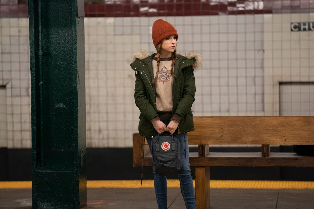 Darby (Anna Kendrick) stands in a subway station holding a backpack.