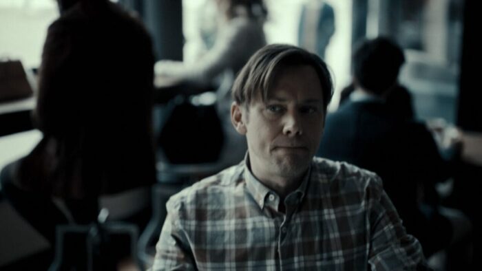 Phil Hayes (Jimmi Simpson) sits at a table hearing voices in his head