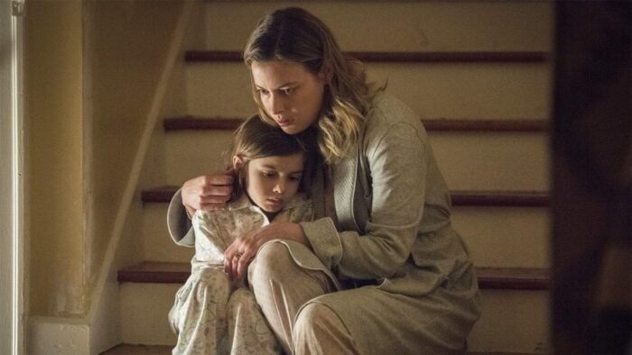 Annie Mitchell (Gillian Jacobs) sits with her daughter on a set of stairs