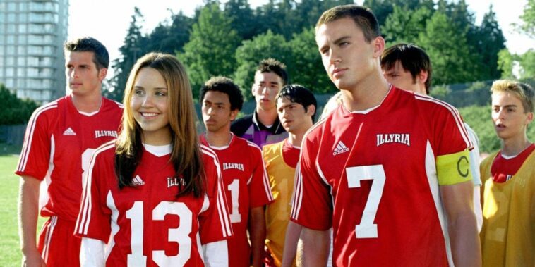 Amanda Bynes and Channing Tatum in soccer uniforms, Bynes is smiling and looking to her right, Channing looks focused and is staring ahead, other soccer players in similar uniforms are behind them in She's The Man