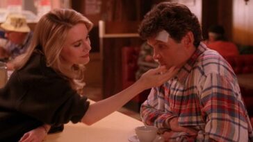 In the Double R Diner, Norma reaches over the counter and lovingly touches Ed's face. Ed has a bandage on his head and looks concerned.