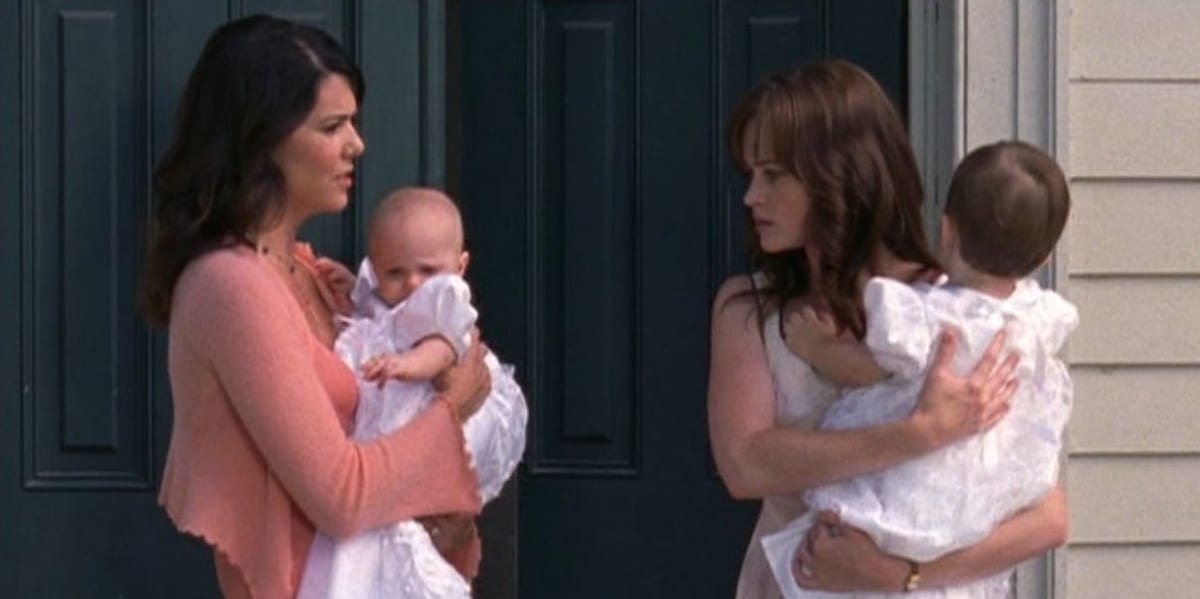 Lorelai and Rory looking at each other angrily, each holding a baby in Gilmore Girls