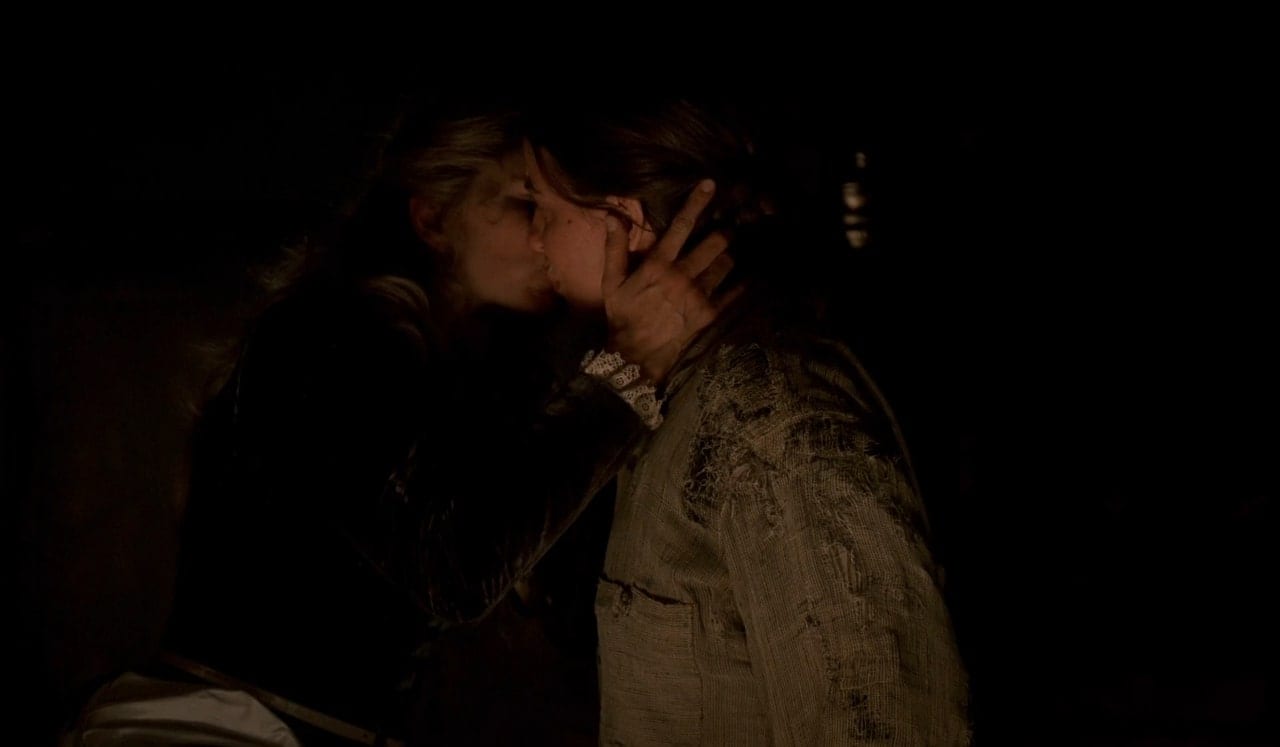 Joanie (Kim Dickens) kisses Jane (Robin Weigert) in a scene from Deadwood.