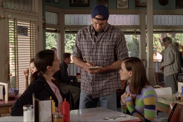 Luke serves Rory and Lorelai at his diner
