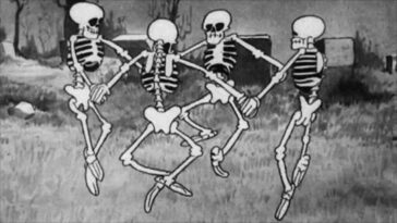 A bunch of cartoon skeletons dance in a graveyard