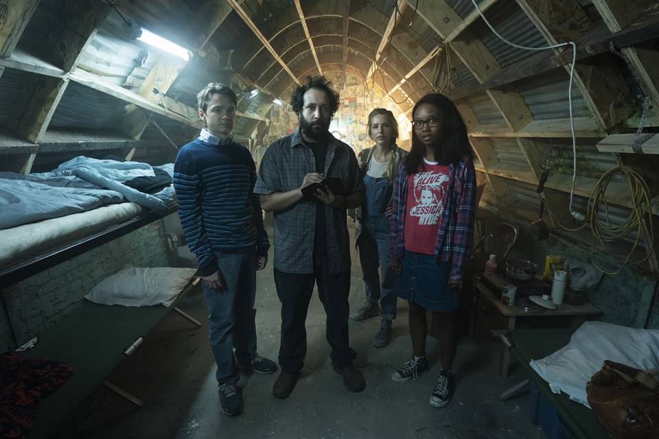 Ian, Wilson, Sam, and Becky stand in Wilson's bunker