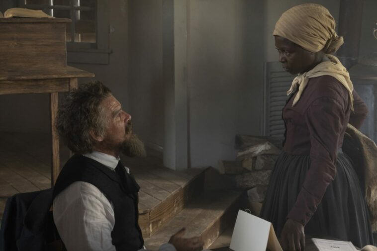John Brown (Ethan Hawke) sitting at a desk on the left looking up at Harriet Tubman (Zainab Jah) as she looks down at him
