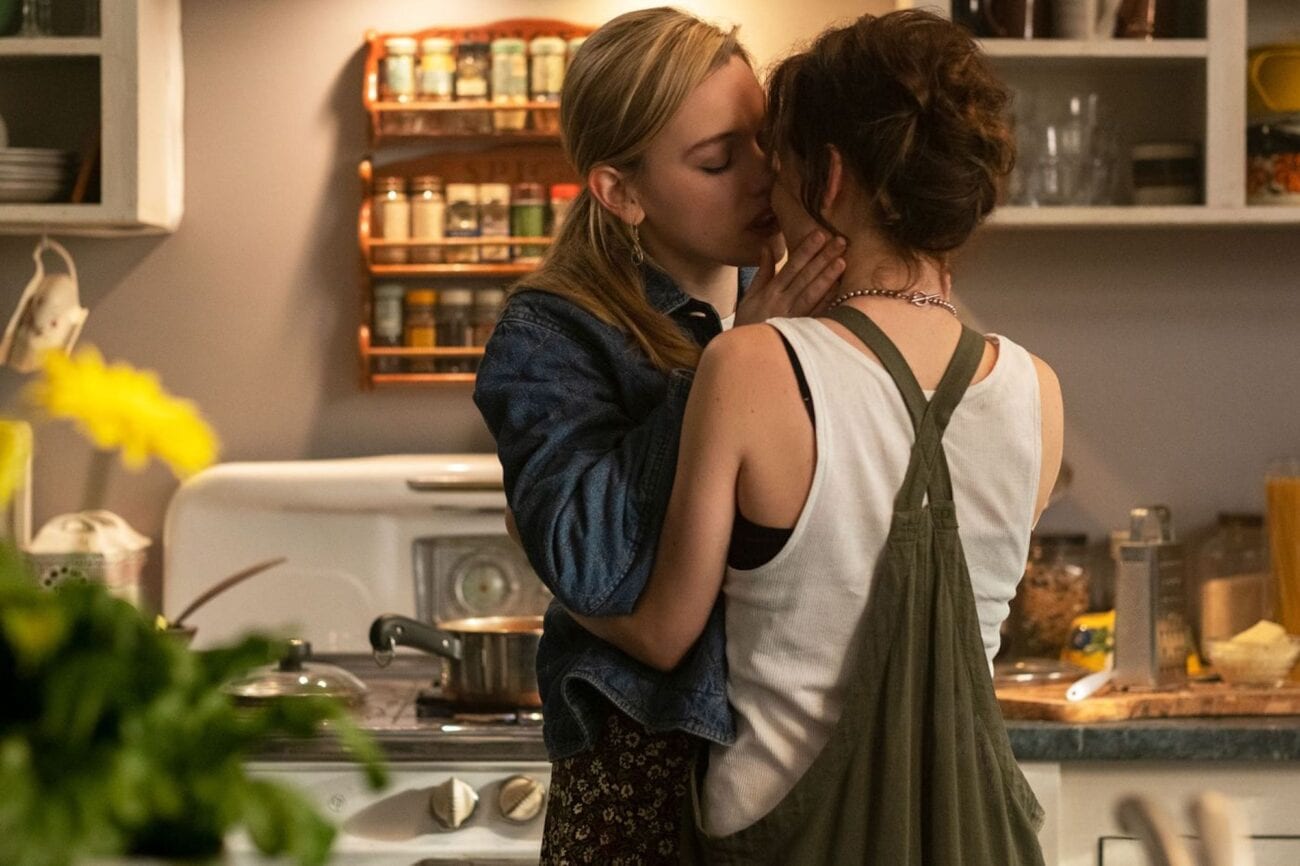 Dani and Jamie kiss in the kitchen of their apartment