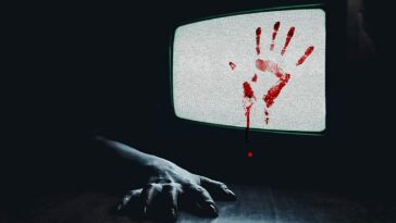 TV showing static with a bloody handprint on it, and an arm on the floor reaching out