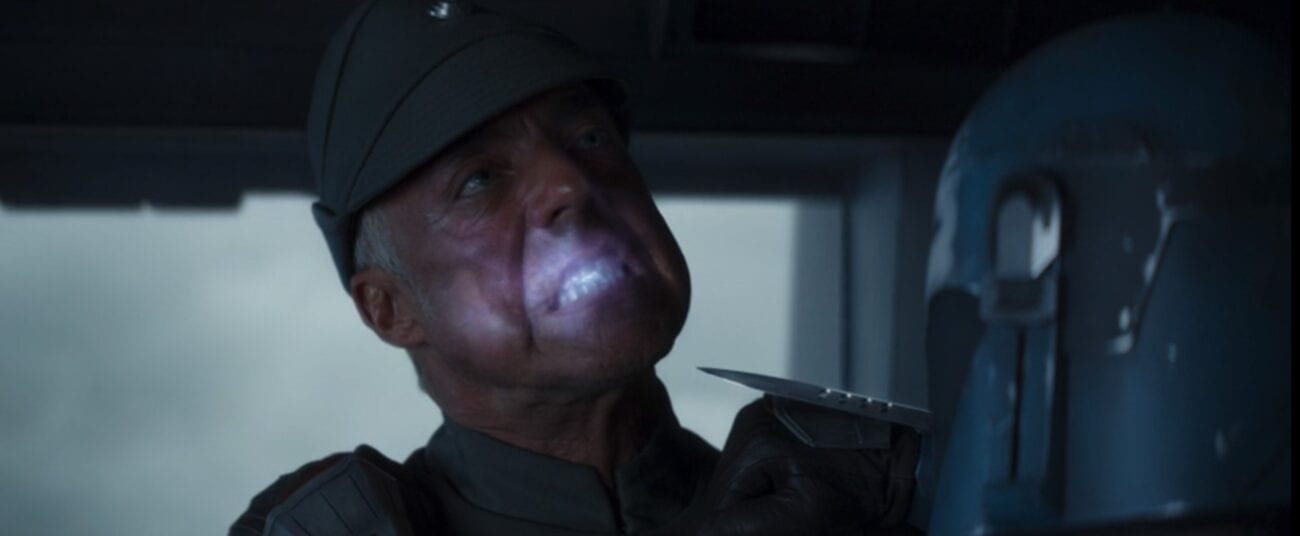 The Imperial captain bites an electric suicide pill, while Bo-Katan holds a knife to his throat