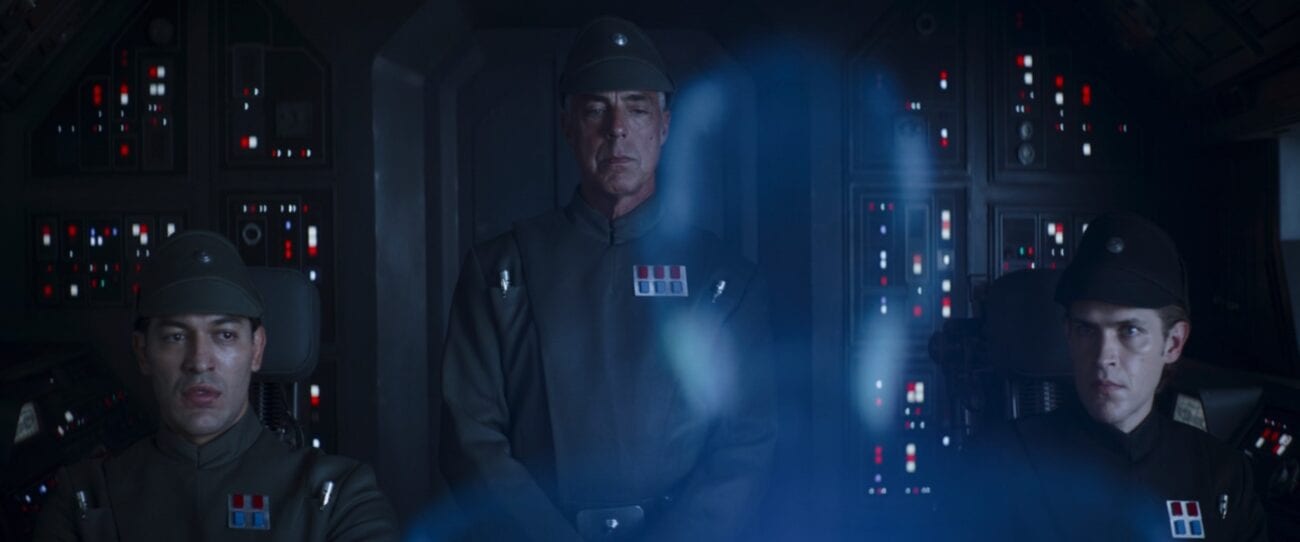 An Imperial captain talks to Moff Gideon in hologram form, while two pilots watch