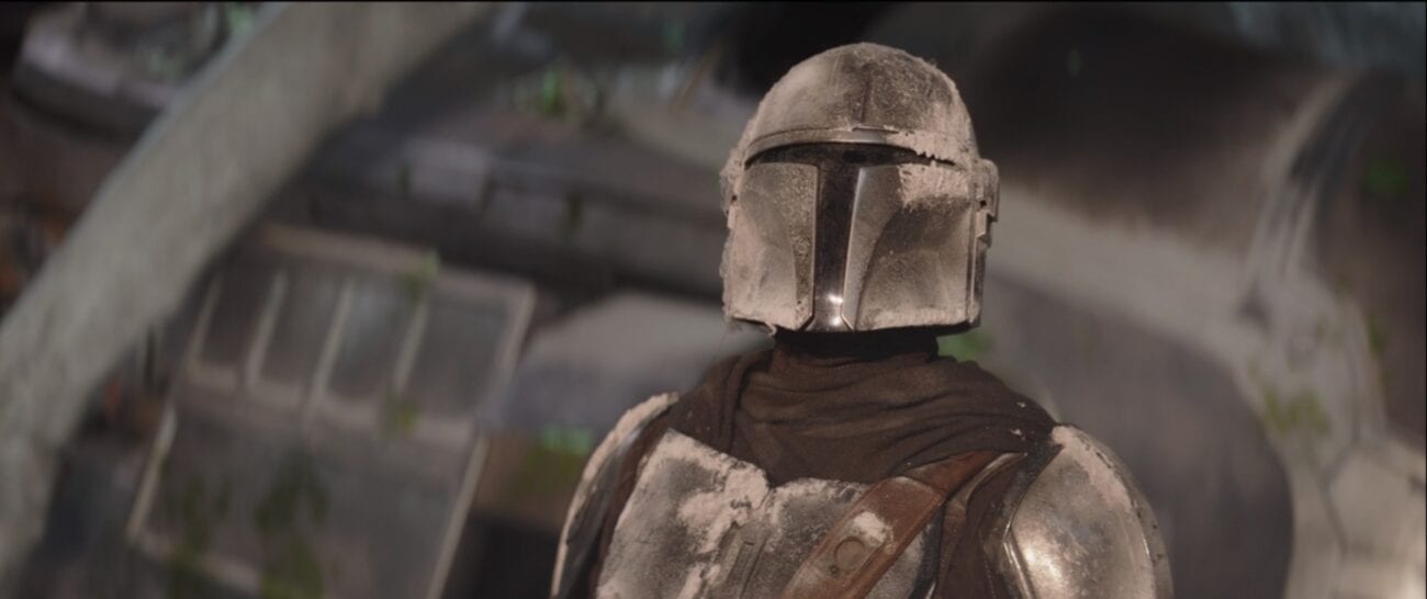 The Mandalorian stands in front of his broken ship