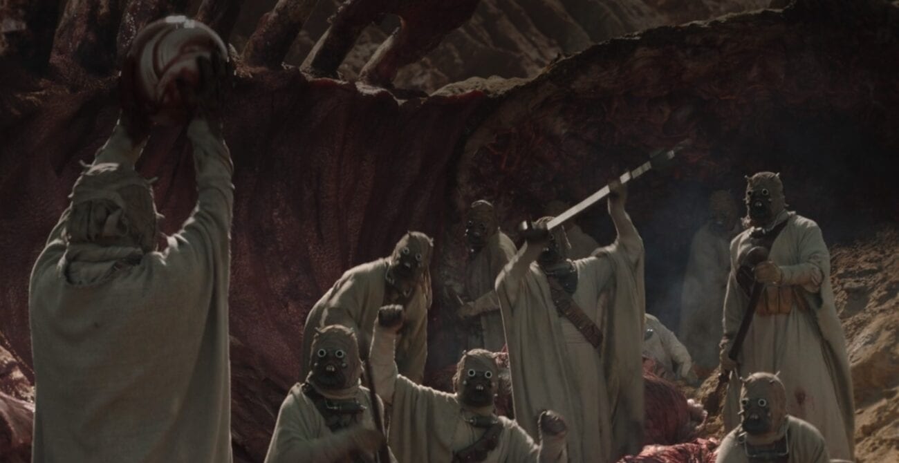 Tusken Raiders celebrate as one holds a newly found krayt pearl over his head