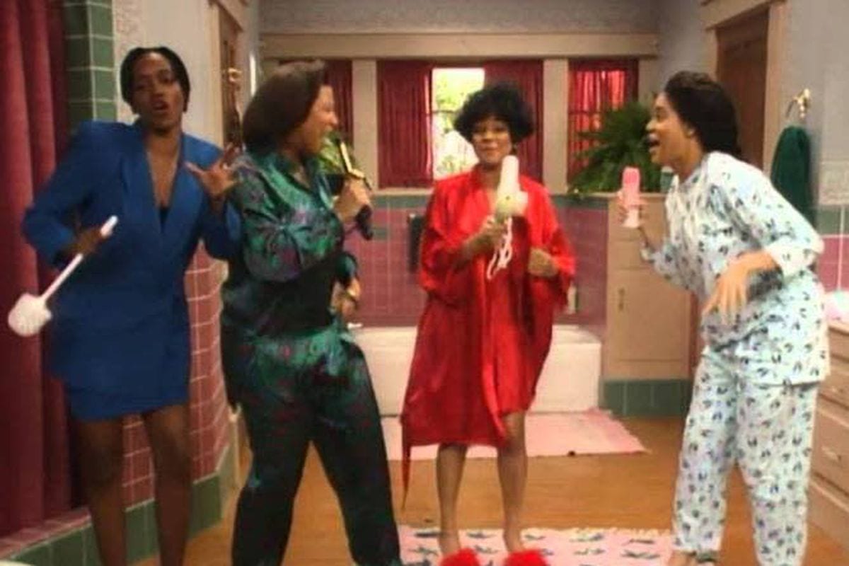 The women of Living Single sing into hairbrushes in their bathroom