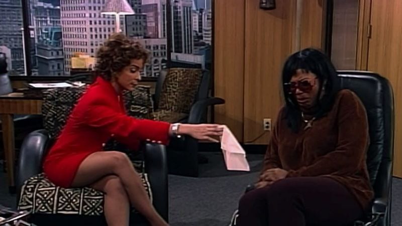 Khadijah at a therapist's office, in sunglasses and a wig. The therapist is handing her a tissue