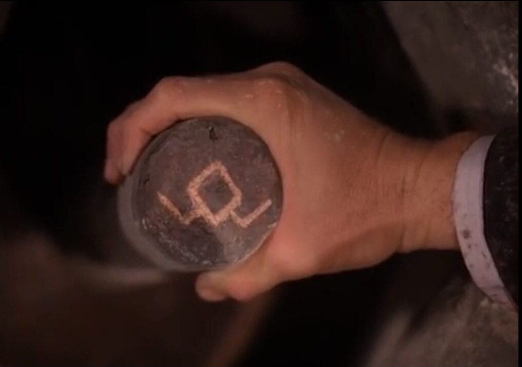 The owl symbol, turned upside down, while Earle’s hand turns the post more.