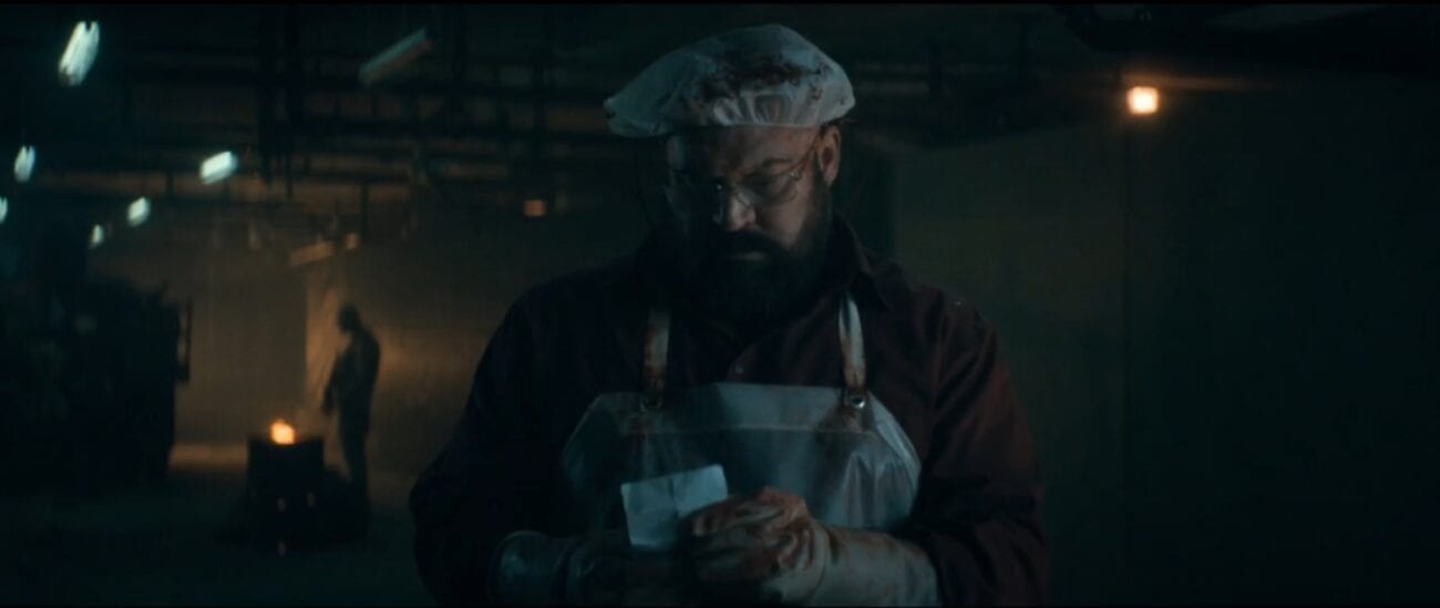 The Stand S1E5 - Tom Collen stand in bloodied butcher's apron holding a piece of paper in his hands