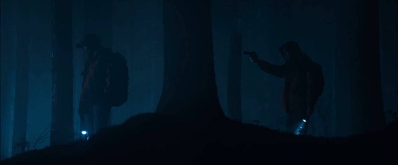 The Stand S1E6 - Stu and Harold in the dark in the woods, Harold holds a gun pointed at Stu's back