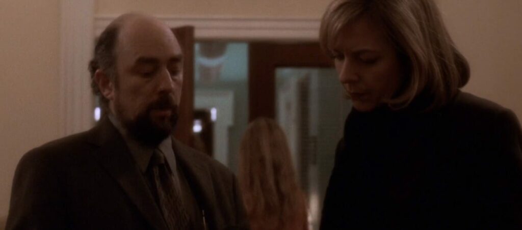 Toby (Richard Schiff) and CJ (Allison Janney) walking through a West Wing corridor