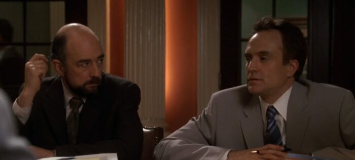 Toby (Richard Schiff) looks at Josh (Bradley Whitford) with his hand by his head, in the Mural Room