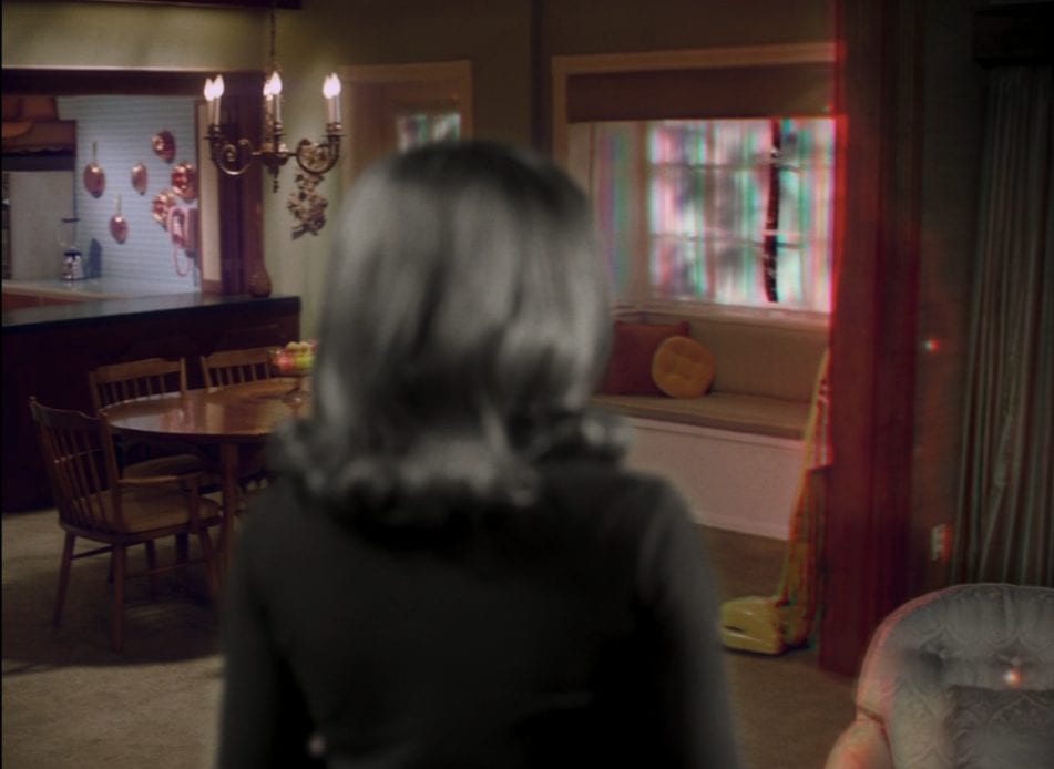 Wanda Maximoff (Elizabeth Olsen) looks as her living room turns technicolor in Marvel and Disney+'s WandaVision
