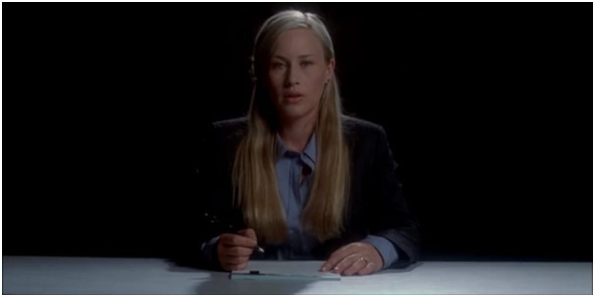 Allison in a suit sitting on opposite side of a table in Medium