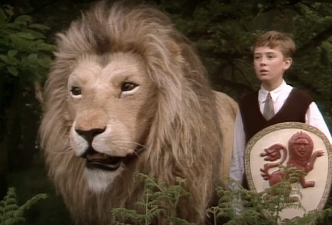 Peter holds a shield and stands next to Aslan