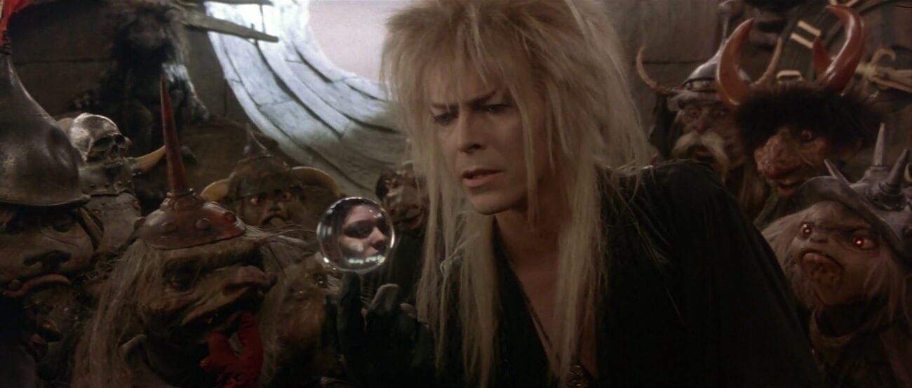 Surrounded by goblins, Jareth looks at Sarah in his crystal ball