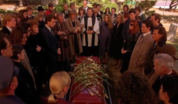 funeral attendees gather around Lauras coffin