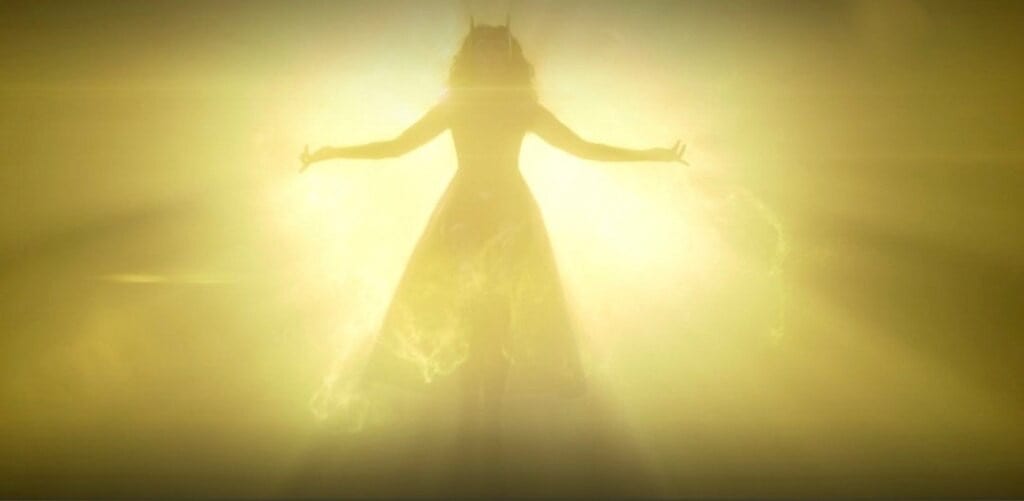 A silhouette of the Scarlet witch, bathed in gold energy, before it descends into Wanda Maximoff.