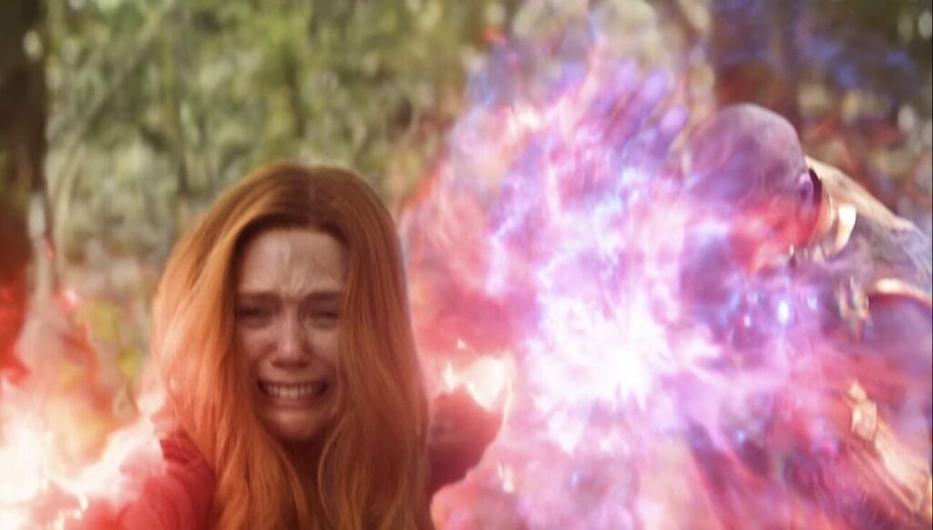 Wanda holding back Thanos from behind while she is visibly distressed destroying the infinity gem in Vision.